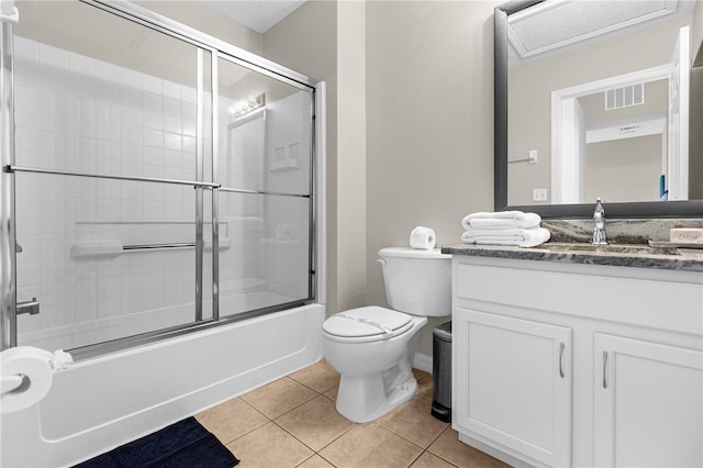 full bathroom featuring tile patterned floors, vanity, toilet, and bath / shower combo with glass door