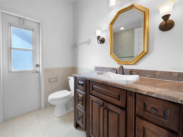 bathroom featuring tile patterned flooring, vanity, tile walls, and toilet