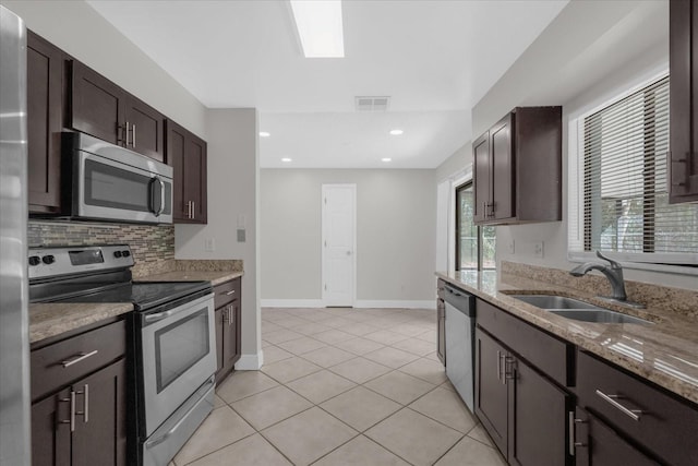 kitchen featuring dark brown cabinets, appliances with stainless steel finishes, sink, and light tile patterned flooring