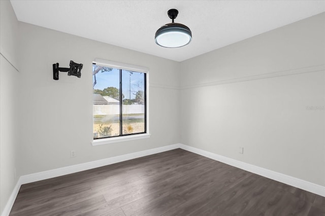 empty room with a healthy amount of sunlight and dark hardwood / wood-style floors