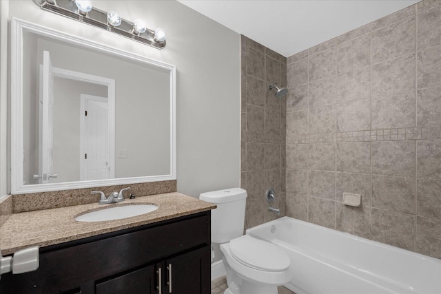 full bathroom with toilet, tiled shower / bath combo, and vanity