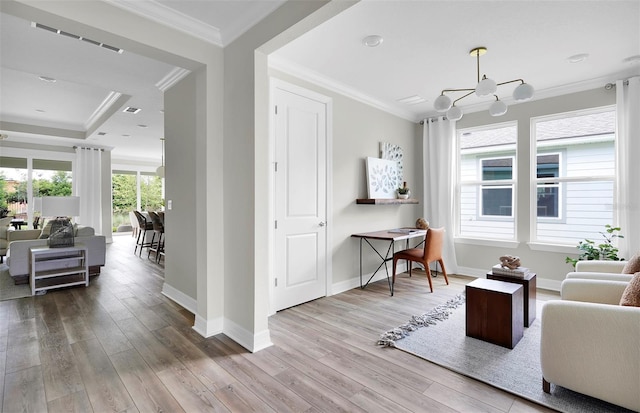 living room featuring a chandelier, light wood-type flooring, and ornamental molding