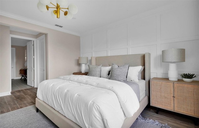 bedroom featuring crown molding, a chandelier, and dark hardwood / wood-style floors