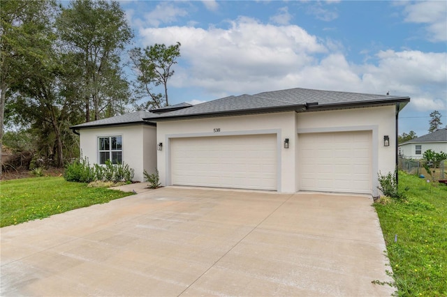 view of front facade with an attached garage, driveway, roof with shingles, stucco siding, and a front yard