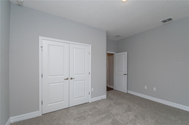 unfurnished bedroom featuring light carpet, baseboards, visible vents, and a closet