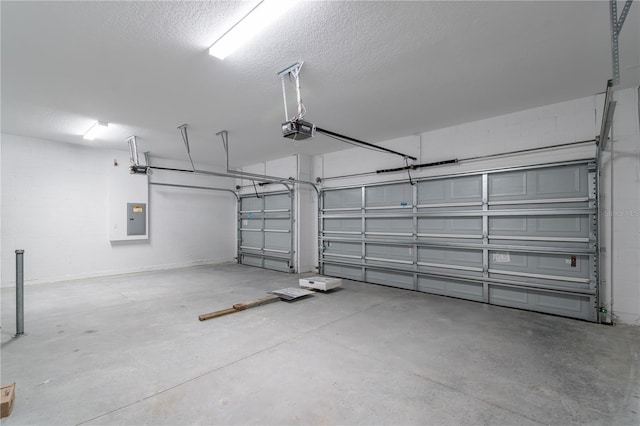 garage featuring concrete block wall, electric panel, and a garage door opener