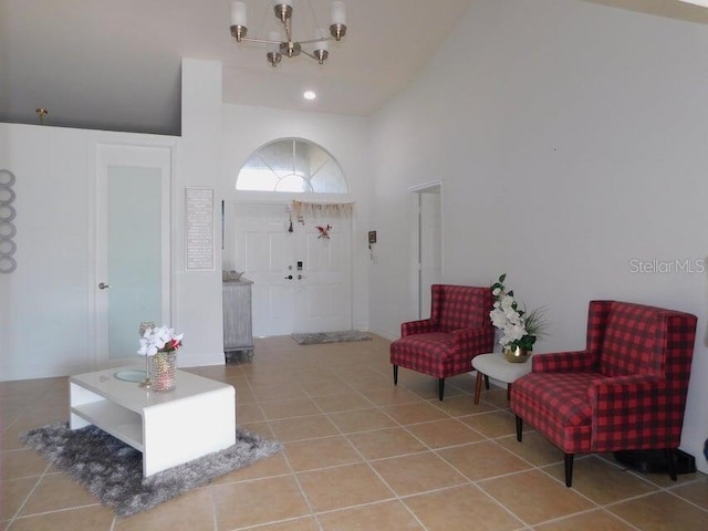 tiled foyer entrance featuring a chandelier and a high ceiling