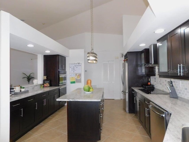 kitchen featuring light stone countertops, a kitchen island, pendant lighting, and appliances with stainless steel finishes