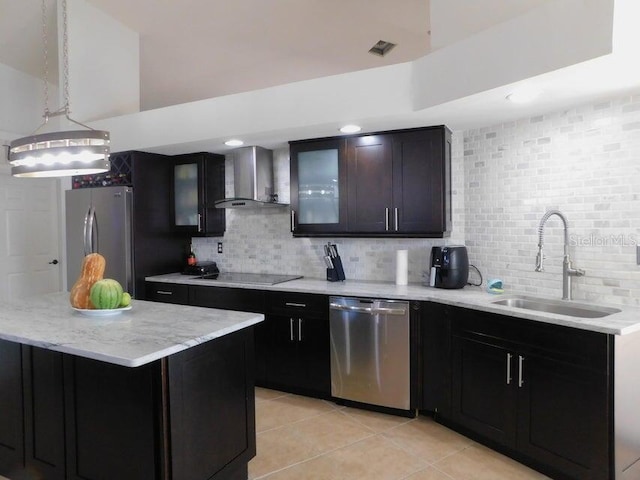 kitchen featuring wall chimney exhaust hood, sink, tasteful backsplash, a kitchen island, and stainless steel appliances