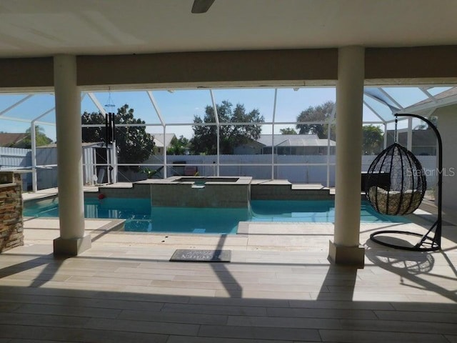 view of swimming pool with an in ground hot tub and a lanai