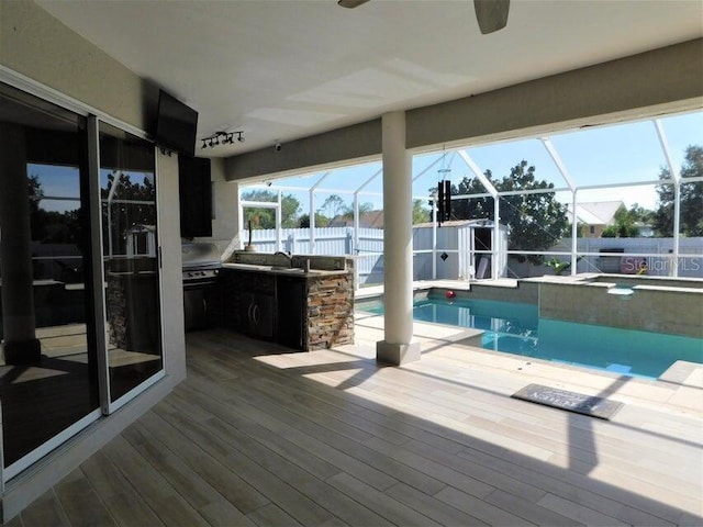 view of swimming pool with a lanai, exterior kitchen, sink, and a patio