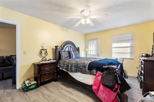 bedroom featuring ceiling fan, a textured ceiling, and light wood-type flooring