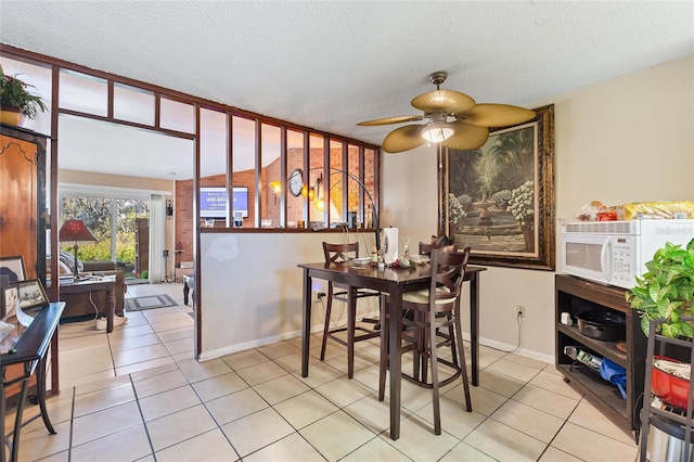 dining room with a textured ceiling, ceiling fan, and light tile patterned flooring