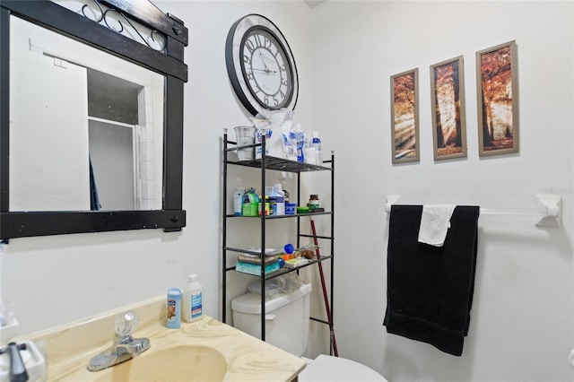 bathroom with a shower with door, vanity, and toilet