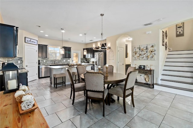 dining room with a chandelier and light tile patterned flooring