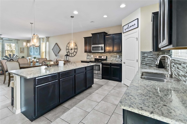 kitchen with sink, a center island, tasteful backsplash, decorative light fixtures, and appliances with stainless steel finishes