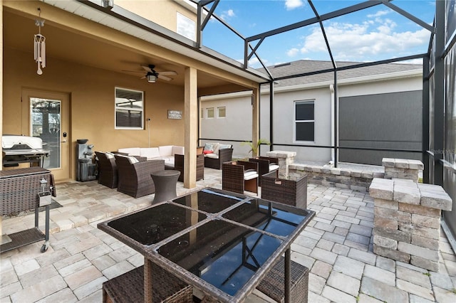 view of patio featuring outdoor lounge area, ceiling fan, glass enclosure, and grilling area