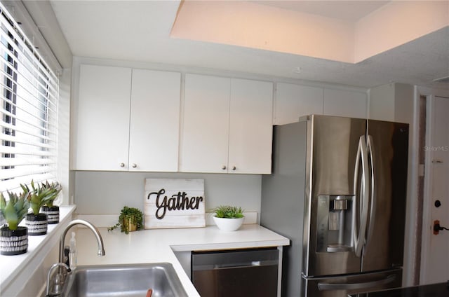 kitchen featuring stainless steel fridge with ice dispenser, light countertops, white cabinetry, a sink, and dishwashing machine