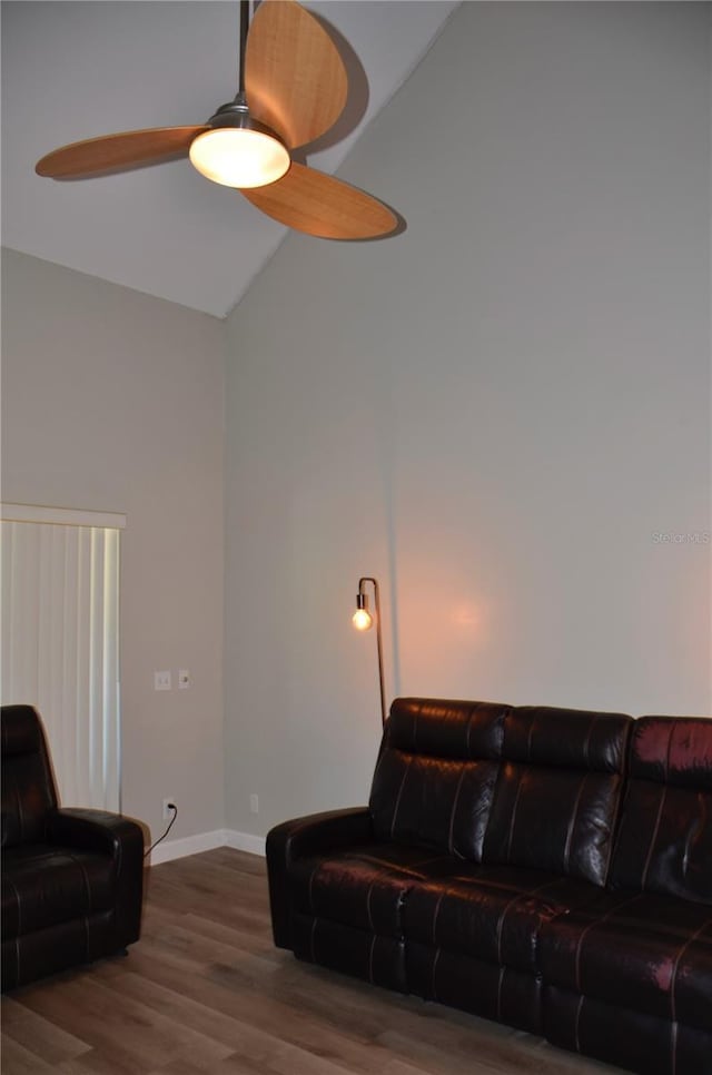 living room with a ceiling fan, lofted ceiling, baseboards, and wood finished floors