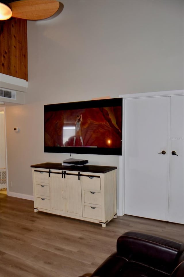 living room featuring visible vents, baseboards, and wood finished floors