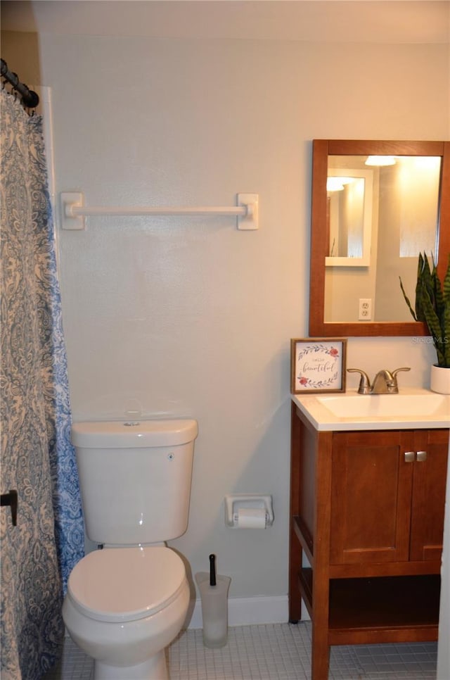 bathroom featuring toilet, vanity, baseboards, and tile patterned floors