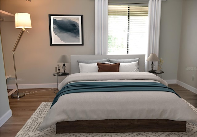 bedroom featuring baseboards and wood finished floors