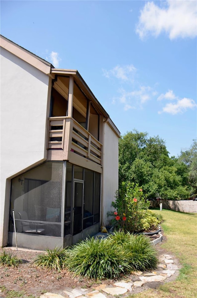 view of side of property with a lawn and stucco siding