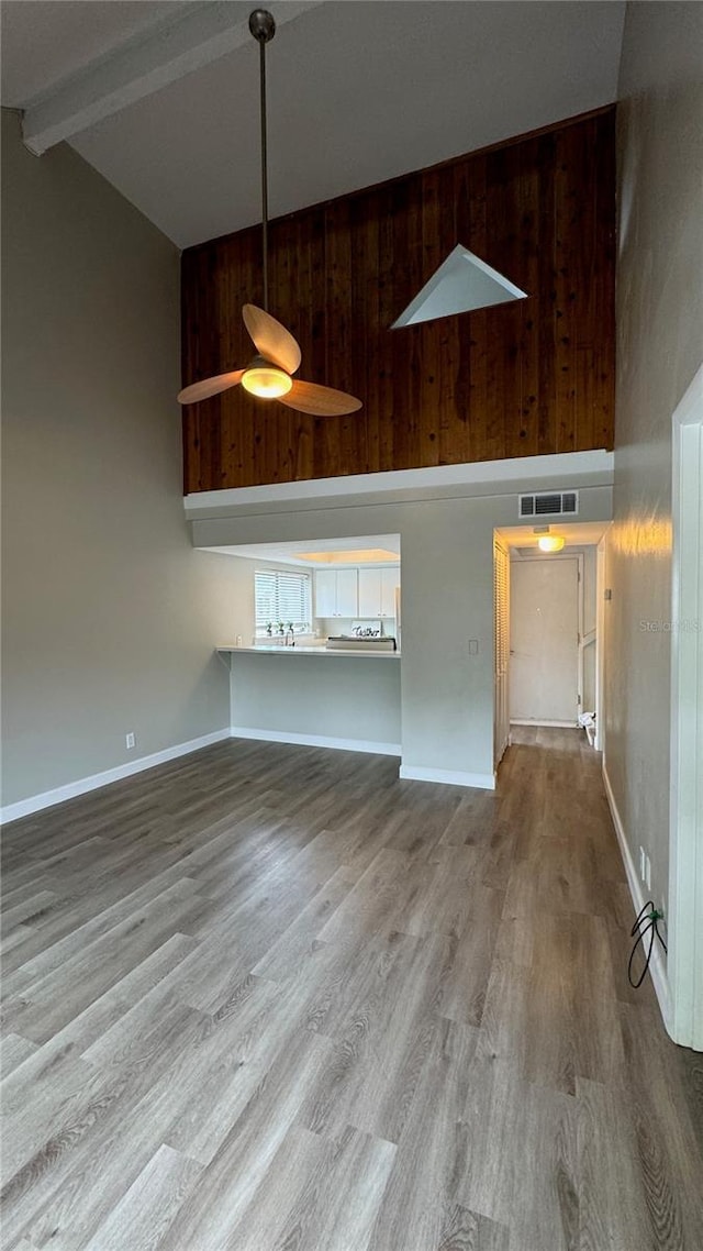 unfurnished living room with high vaulted ceiling, visible vents, and light wood finished floors