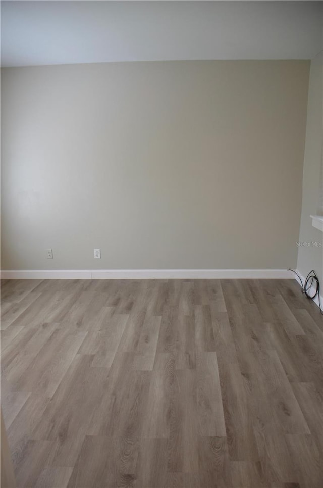 spare room featuring light wood-style flooring and baseboards