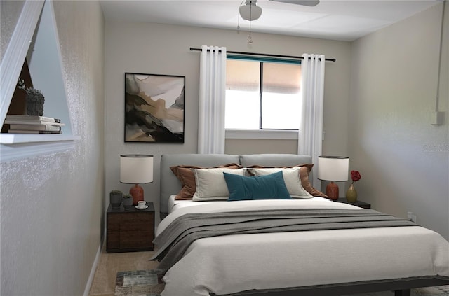 carpeted bedroom featuring a ceiling fan and a textured wall