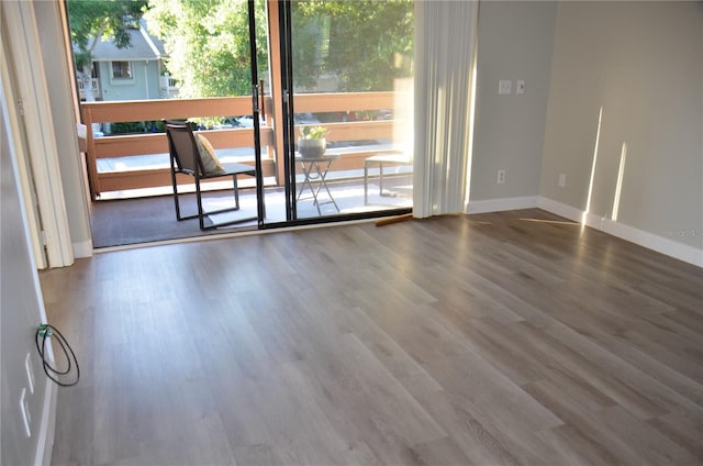 empty room with baseboards and wood finished floors