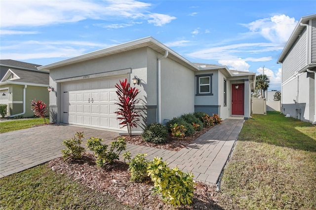 single story home featuring a garage and a front lawn