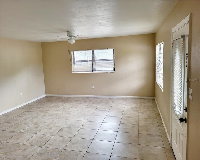 empty room with light tile patterned floors and ceiling fan