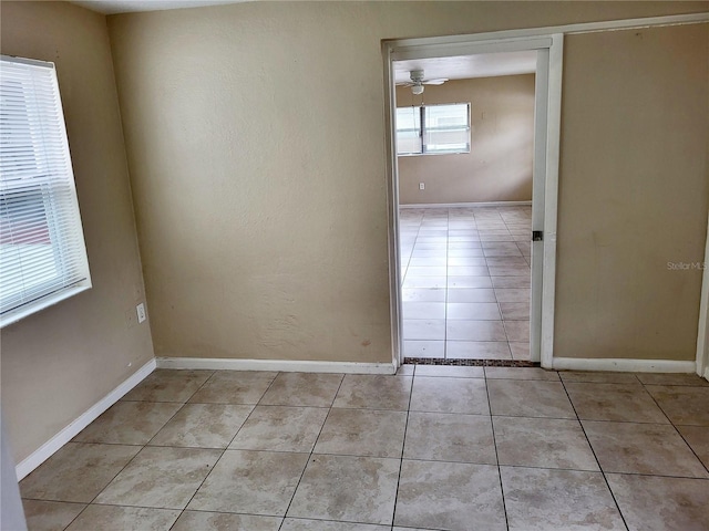 tiled spare room featuring ceiling fan