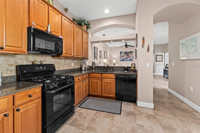 kitchen featuring black appliances, sink, ceiling fan, dark stone countertops, and tasteful backsplash