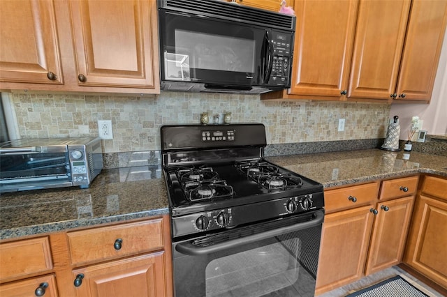 kitchen with black appliances, decorative backsplash, and dark stone countertops