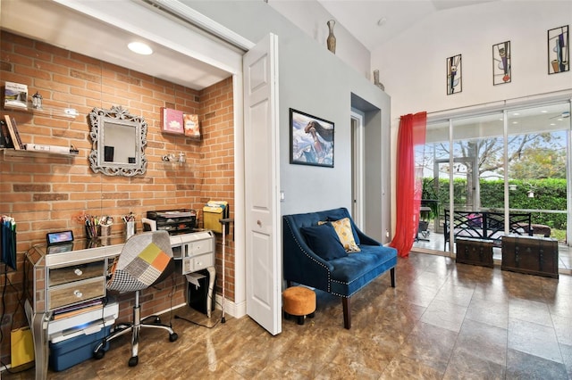 office area featuring brick wall and vaulted ceiling