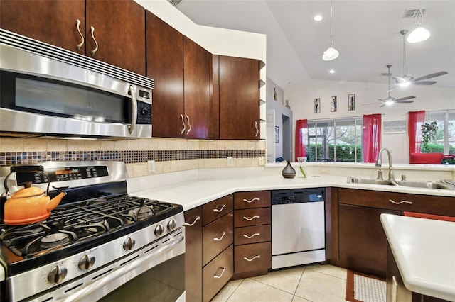 kitchen with sink, vaulted ceiling, decorative backsplash, decorative light fixtures, and stainless steel appliances