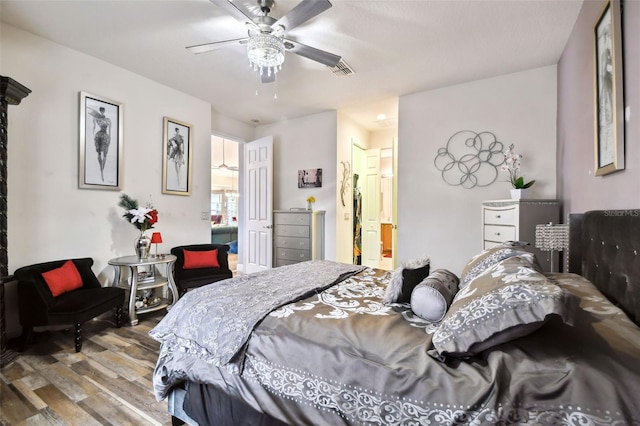 bedroom featuring hardwood / wood-style floors, ceiling fan, and ensuite bath