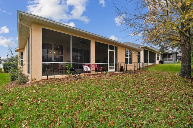 back of property with a yard and a sunroom