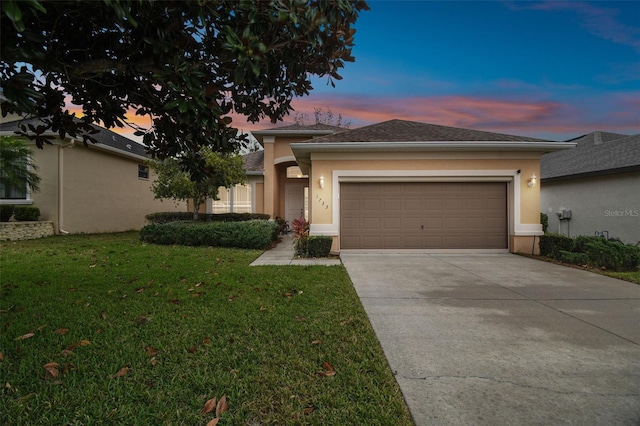 view of front of home with a garage and a yard