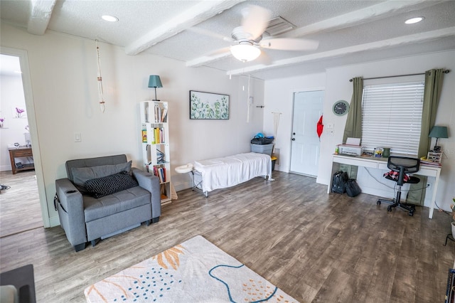 bedroom with beamed ceiling, hardwood / wood-style floors, a textured ceiling, and ceiling fan