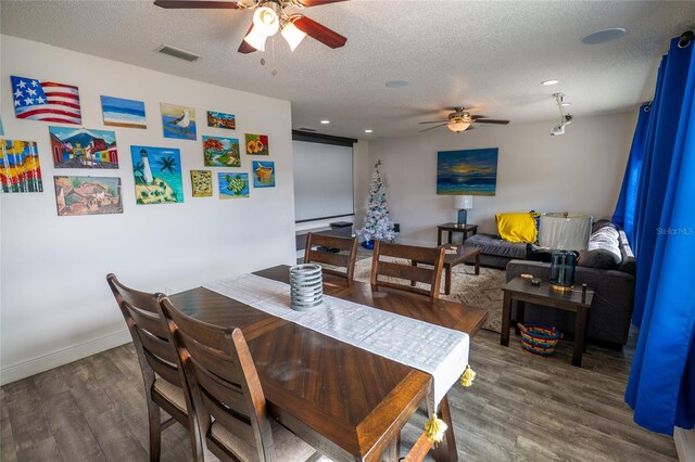 dining space with ceiling fan, dark hardwood / wood-style floors, and a textured ceiling