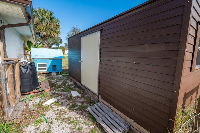 view of property exterior with a storage unit