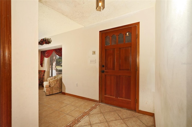 foyer featuring light tile patterned flooring and a textured ceiling