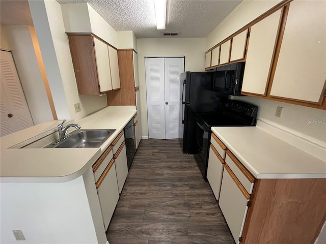 kitchen featuring dark wood-type flooring, black appliances, sink, a textured ceiling, and white cabinetry