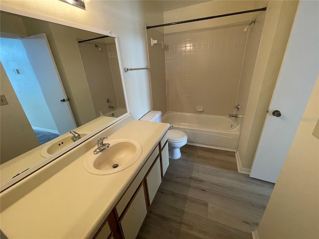 full bathroom featuring hardwood / wood-style floors, vanity, toilet, and tiled shower / bath