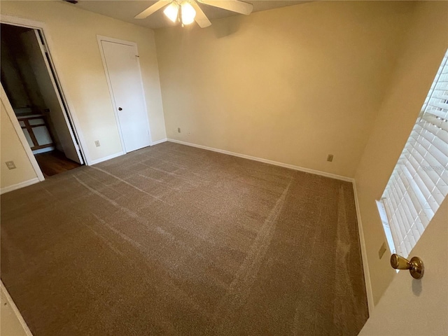 unfurnished bedroom with dark colored carpet and ceiling fan