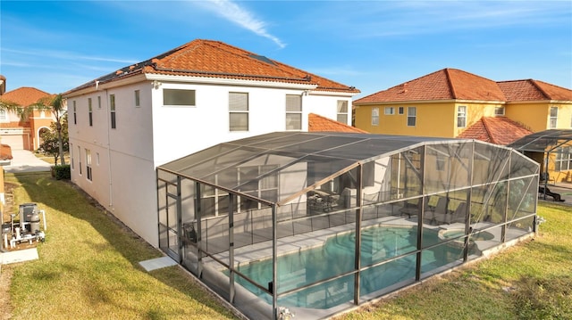 back of house with a yard and glass enclosure