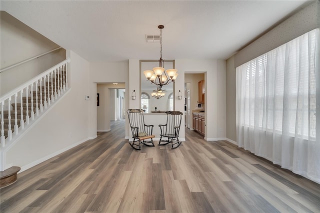 dining space featuring a healthy amount of sunlight, a chandelier, and hardwood / wood-style floors